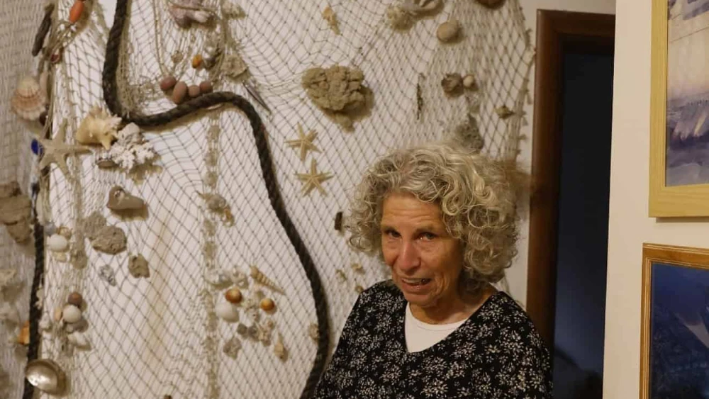 Bryna Hilburg explains the fishing net in the Hilburg home, holding seashells and other memorabilia from Gush Katif. Photo by Yossi Zamir.