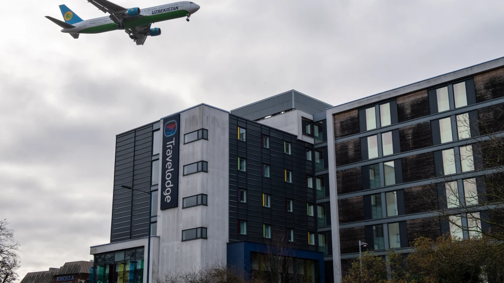 An airplane flies over a Travelodge Hotel as it comes in to land at Heathrow Airport in London on Jan. 28, 2021. Photo by Chris J. Ratcliffe/Getty Images.