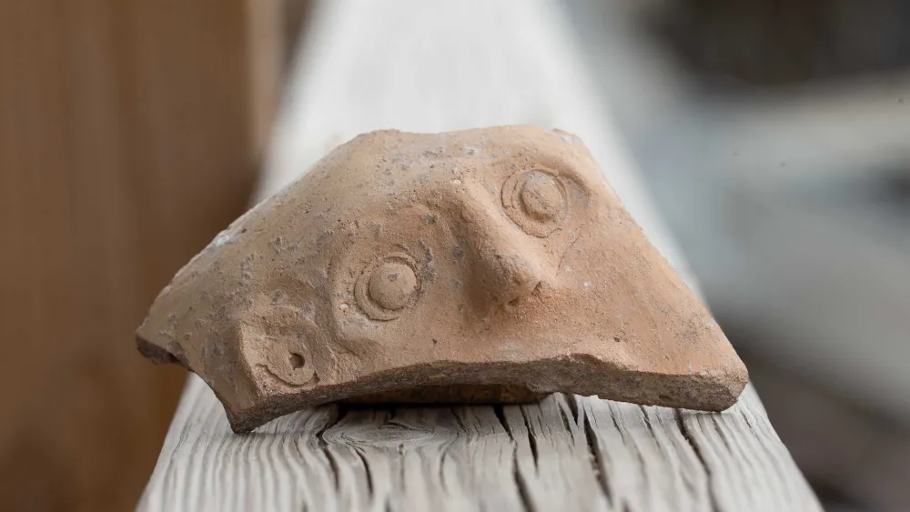 A fragment of a clay jar decorated with a human face dating back to the Persian era (fourth to fifth century C.E.) was discovered in Jerusalem’s City of David National Park’s Givati parking-lot excavation. Credit: Eliyahu Yanai/City of David, Jerusalem.