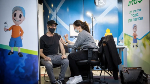Israelis receive a dose of Pfizer's COVID-19 vaccine at a Clalit Health Fund vaccination center in Jerusalem on Jan. 12, 2021. Photo by Yonatan Sindel/Flash90.