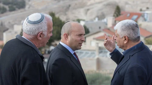 Jewish Home Party leader Naftali Bennett (center) speaks with Ma’ale Adumim Mayor Benny Kasriel (right) before the start of a special Jewish Home faction meeting on Jan. 2, 2018. Bennett has advocated for a Knesset bill to be introduced after president-elect Donald Trump takes office on Jan. 20 calling, for Israel’s annexation of Ma’ale Adumim. Credit: Yonatan Sindel/Flash90.