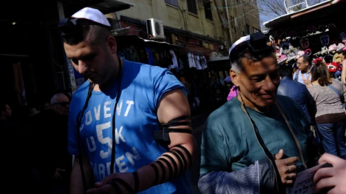 Israeli Jewish men put on tefillin at the entrance to Carmel Market in downtown Tel Aviv on Feb. 10, 2017. Photo by Tomer Neuberg/Flash90.