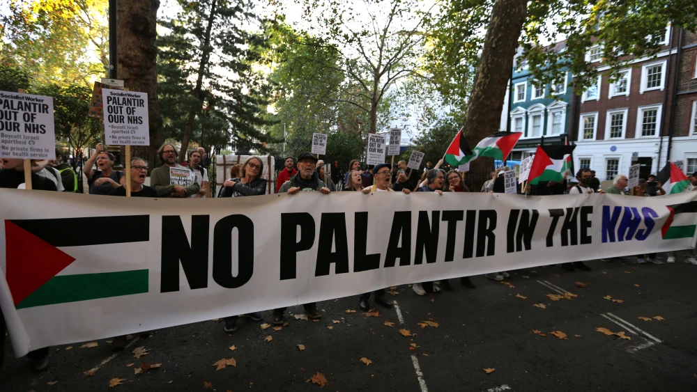 Protesters against NHS cooperation with Israel's Planatir firm hold up a large banner outside their offices in Soho Square during a demonstration in London, England on October 1, 2026. Photo by Martin Pope/Getty Images.