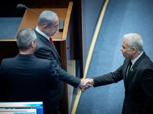 Israeli Prime Minister Benjamin Netanyahu speaks with opposition leader Yair Lapid at a plenum session for the Knesset's 75th birthday, in the assembly hall of the parliament in Jerusalem on Jan, 24, 2024. Photo by Yonatan Sindel/Flash90.