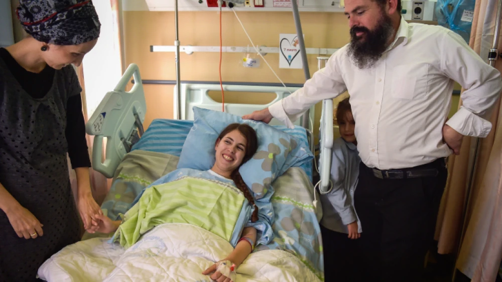 Shuva Malka, the 18-year-old woman who was stabbed and seriously wounded in a terror attck last week, is seen at HaEmek Medical Center in Afula with relatives on June 17, 2018. Photo by Meir Vaknin/Flash90.