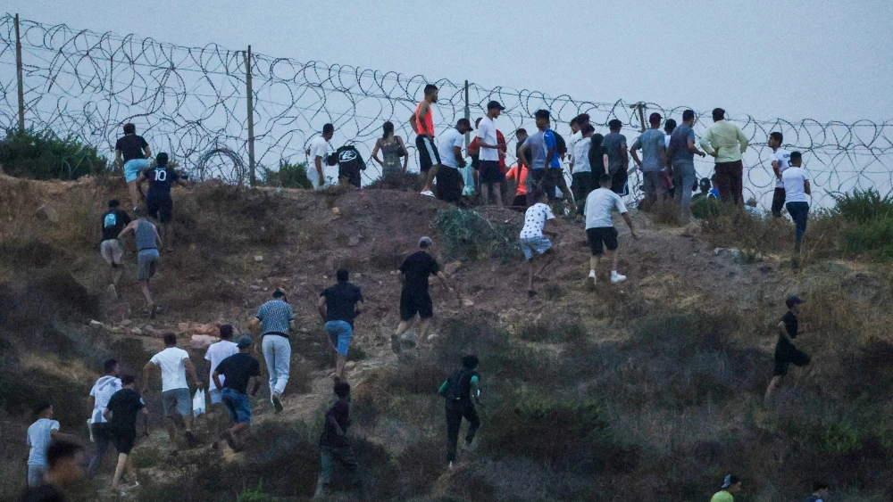 People gather on a hilltop near Bab Sebta on the Morocco-Spain border, near Spain's enclave of Ceuta and the Moroccan town of Fnideq on July 30, 2026. Photo by Abdelmajid BZIOUAT / AFP via Getty Images.
