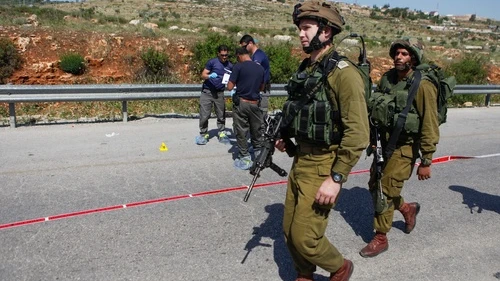 Israeli security forces inspect the site of a terror attack, at a bus stop at the Tapuach Junction on April 30, 2013. The Palestinian terrorist stabbed a 31-year-old Israeli man to death at a bus stop, police said. Credit: Flash90.