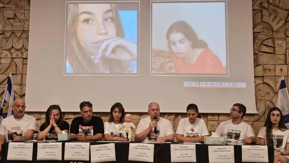 Shlomi Berger, the father of hostage Agam Berger, speaks in Tel Aviv with images of his daughter before and after her abduction in the background. Photo by Paulina Patimer.