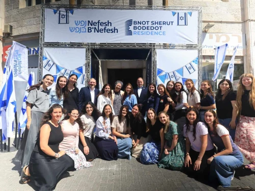 Young women volunteering in Israel's National Service pose for a photograph at the entrance to the new Nefesh B'Nefesh Bnot Sherut Bodedut Residence, Sept. 7, 2025. Photo by Yonit Schiller.