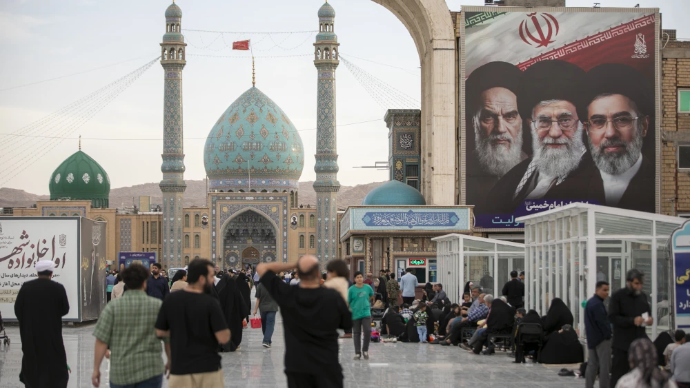 A banner with images of Iran's late and new supreme leaders, Ayatollah Ruhollah Khomeini, Ayatollah Ali Khamenei, and Ayatollah Mojtaba Khamenei is seen at the entrance of Jamkaran Mosque during Eid al-Adha on May 26, 2026 in Qom, Iran. Photo by Majid Saeedi/Getty Images.