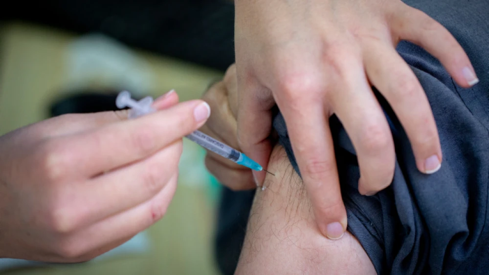 An Israeli receives a COVID-19 vaccine at the HMO Clalit's vaccination center in Jerusalem, on Dec. 23, 2020. Photo by Olivier Fitoussi/Flash90.