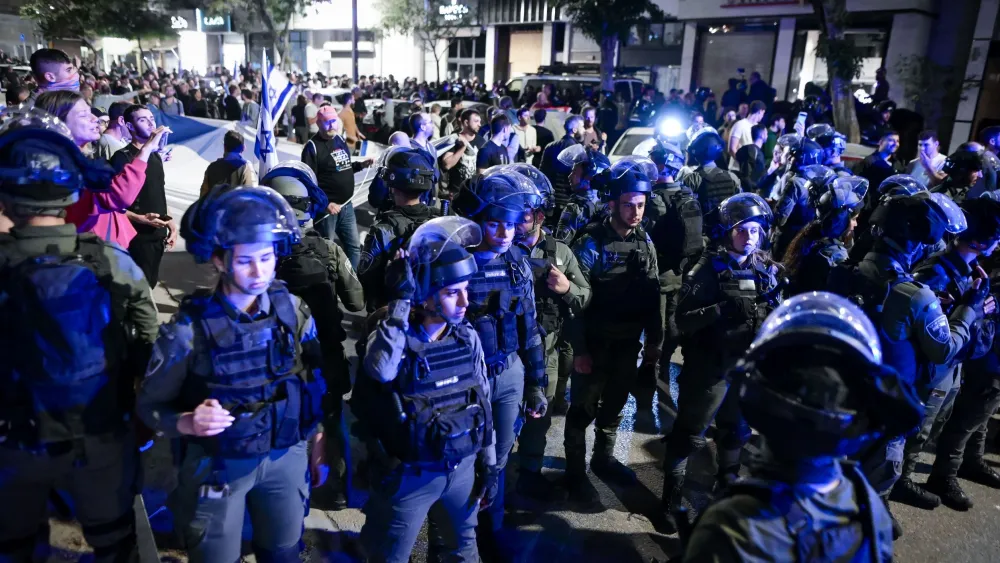 Police officers stand guard while Israelis demonstrate against Prime Minister Benjamin Netanyahu's wife Sara Netanyahu, outside a hair salon in Tel Aviv on March 1, 2023. Photo: Avshalom Sassoni/Flash90