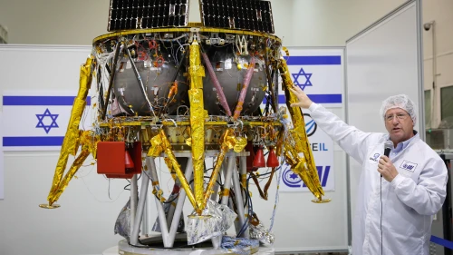 Ofer Doron, head of IAI's MBT Space Division speaks near the Israeli spacecraft of the SpaceIL team's spacecraft, during a press conference at the Israel Aerospace facility in Yahud on July 10, 2018. Photo by Flash90.