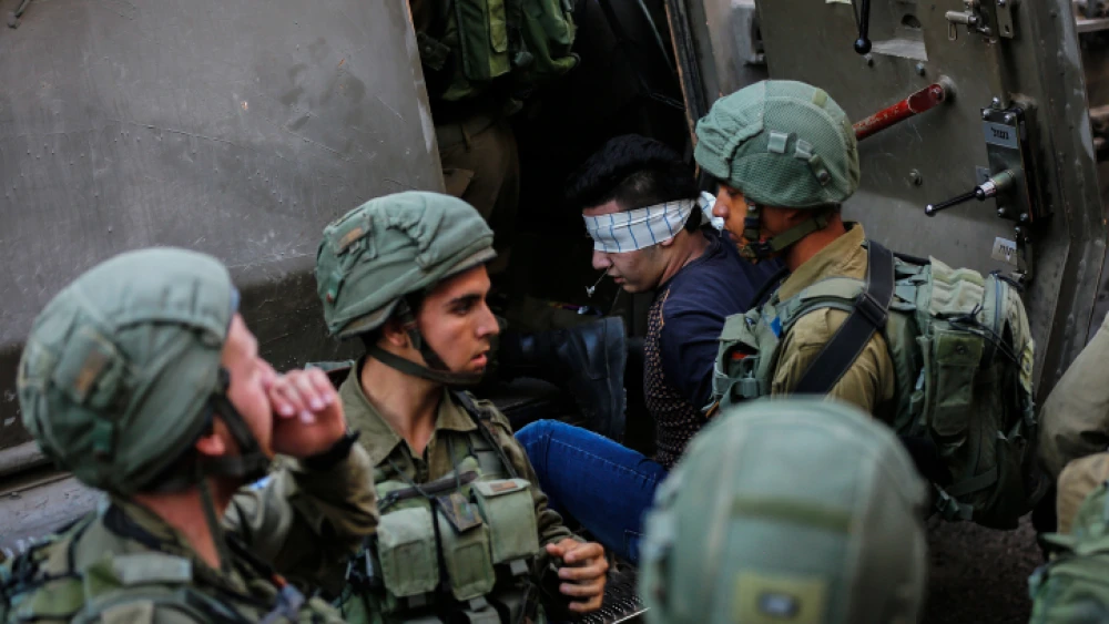 Illustrative: Israeli soldiers arrest a Palestinian man during raids in Hebron on Sept. 20, 2017. Photo by Wisam Hashlamoun/Flash90.