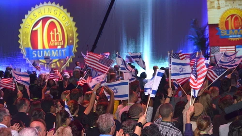 Attendees of the 10th Christians United for Israel Washington Summit wave Israeli and American flags on Monday night. The next morning brought an announcement of a nuclear deal between Iran and world powers. Credit: Maxine Dovere.