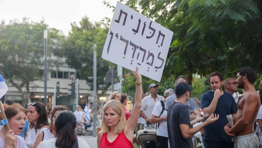 A woman holds a sign reading "Strictly secular" at a demonstration against a gender-segregated Yom Kippur prayer service at Dizengoff Square in Tel Aviv on Yom Kippur, Sept. 25, 2023. Photo by Itai Ron/Flash90.