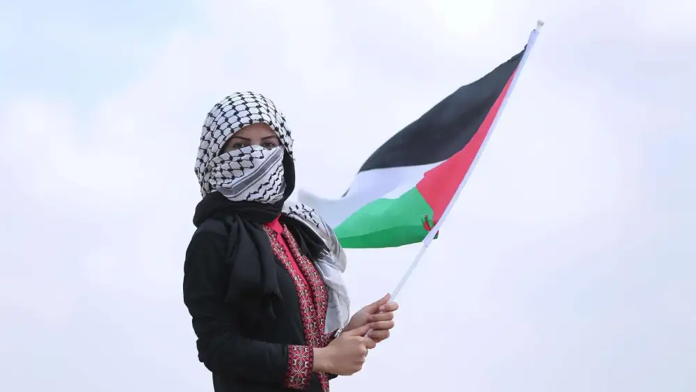 Woman Wearing a Keffiyeh and Holding Palestinian Flag