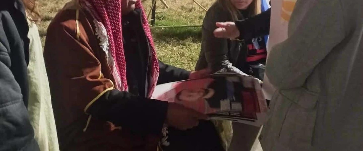 Sheikh Khaled, a resident of Rahat, shows pictures of relatives being held by Hamas in Gaza to supporters and other hostages' families at Tel Aviv's Hostage Square, on Feb. 10, 2024. Photo by Amelie Botbol.