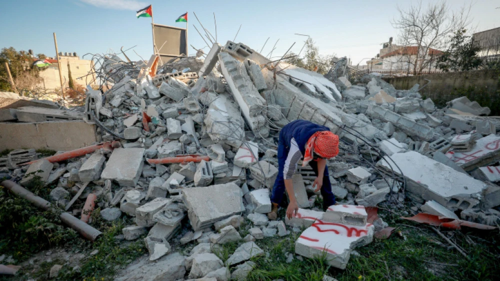 A Palestinian man walks on the rubble of the family house of suspected Palestinian terrorist Yazan Mughamis after it was demolished by Israeli forces in the West Bank town of Birzeit on March 5, 2020. Photo by Flash90.