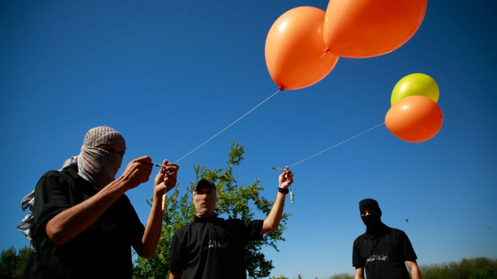 Masked Palestinian supporters of Palestinian Islamic Jihad prepare incendiary balloons east of Gaza City to launch across the border fence towards Israel, June 15, 2021. Photo by Atia Mohammed/Flash90.