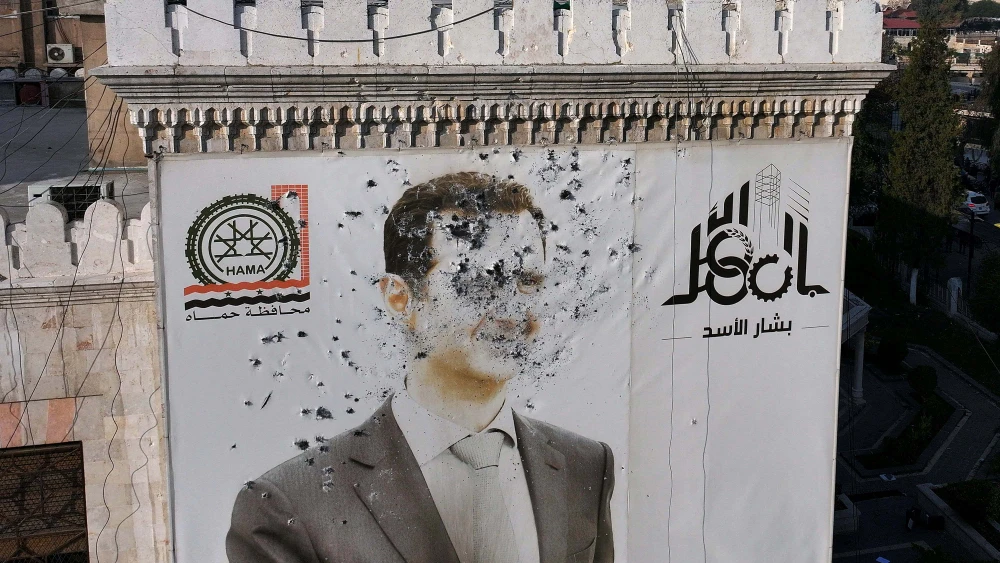 A bullet-riddled portrait of Syrian President Bashar Assad adorning Hama's municipality building after it was defaced following the capture of the city by anti government fighters on Dec. 6, 2024. Photo by Omar Haj Kadour/AFP via Getty Images.