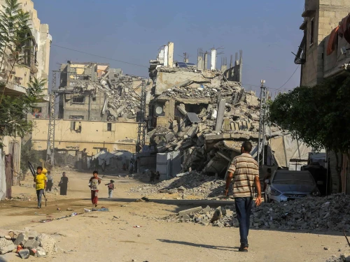 Palestinians walk past buildings destroyed in the recent war, in the Jorat al-Luth area, located between Rafah and Khan Yunis in the southern Gaza Strip, November 10, 2025. Photo by Abed Rahim Khatib/Flash90.