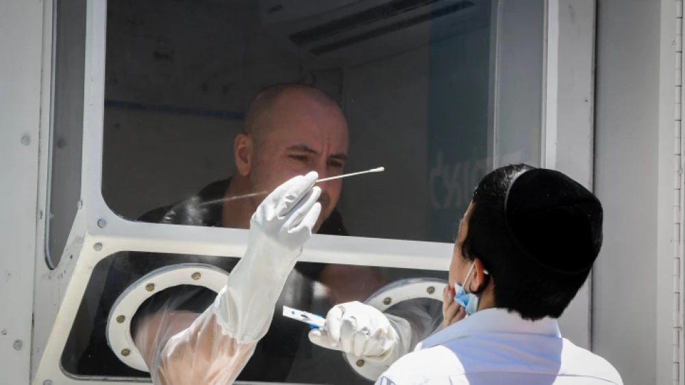 A medical worker tests for COVID-19 at a mobile testing station in the city of Elad on June 24, 2020. Photo by Flash90.