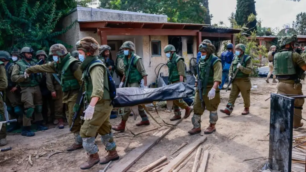 Israeli soldiers remove bodies of civilians in Kibbutz Kfar Aza, Oct. 10, 2023. Photo by Chaim Goldberg/Flash90.
