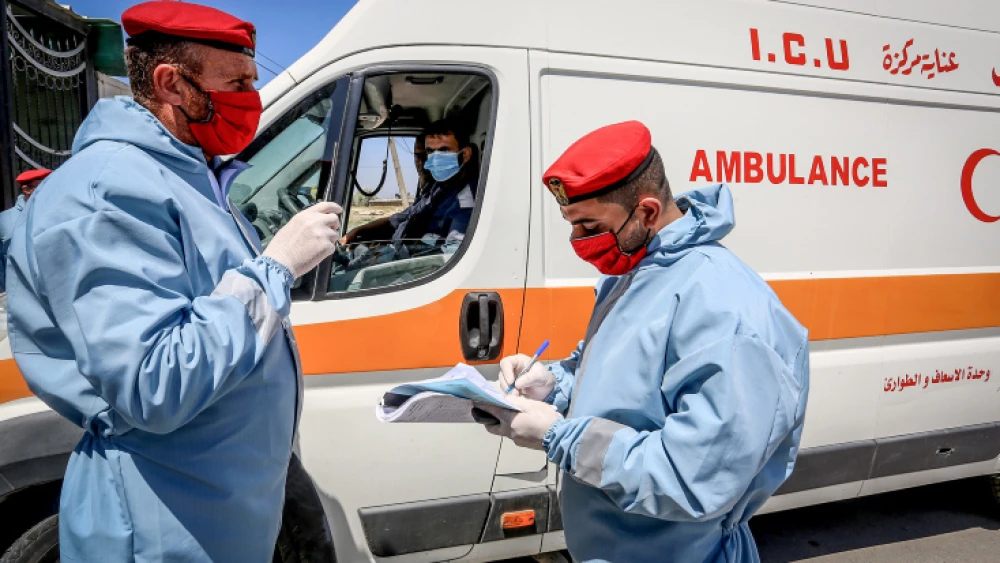 Security forces loyal to Hamas check the papers of an intensive-care ambulance during the coronvirus pandemic at the Rafah border crossing with Egypt in the southern Gaza Strip, April 13, 2020. Photo by Abed Rahim Khatib/Flash90.