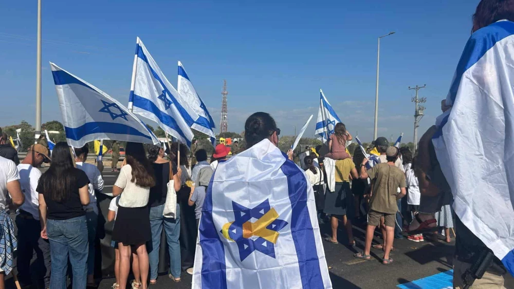 Israelis gather along Road 232 near the IDF’s Re’im base to welcome home the freed hostages, Oct. 13, 2025. Photo by Amelie Botbol.