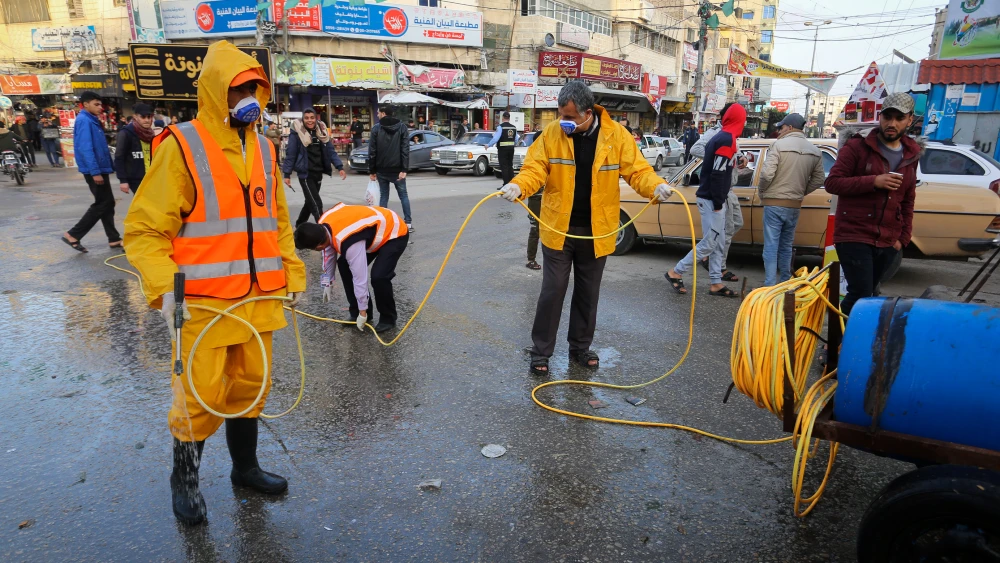 Municipality workers wearing protective clothes disinfect a street in Khan Younis in the southern Gaza Strip as part of measures to prevent the spread of the coronavirus, March 14, 2020. Photo by Abed Rahim Khatib/Flash90.