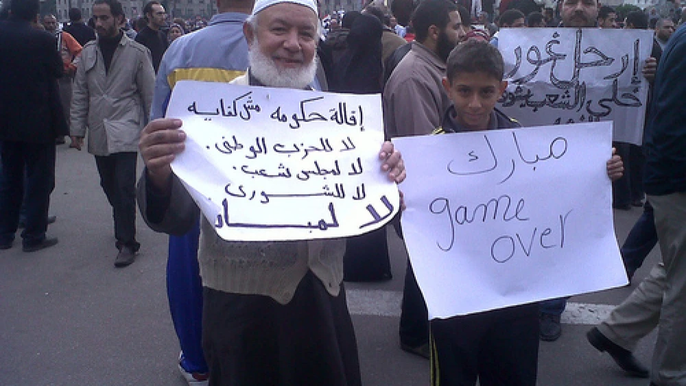 Click photo to download. Caption: (From left to right) In Egypt on Jan. 30, 2011, one protester's sign reads "The stepping down of the government is not enough.. No to the NDP, No to the MPs.. No to Mubarak," and the other's reads "Mubarak Game Over." Credit: BanyanTree.