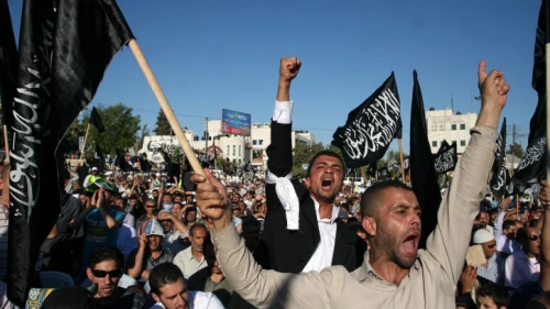 Palestinian supporters of Hizb ut-Tahrir, or the Islamic Liberation Party, chant slogans and wave black and white flags reading "There is no God but God, and Muhammad is his prophet" during a rally in Ramallah on July 7, 2012. Photo by Issam Rimawi/Flash90.