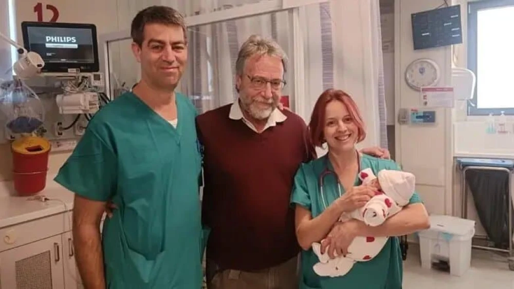 Tamar Levi's daughter with Dr. Shay Porat (left), Dr. Marc Zerah (center) and another medical staffer. Credit: Hadassah Spokesperson.