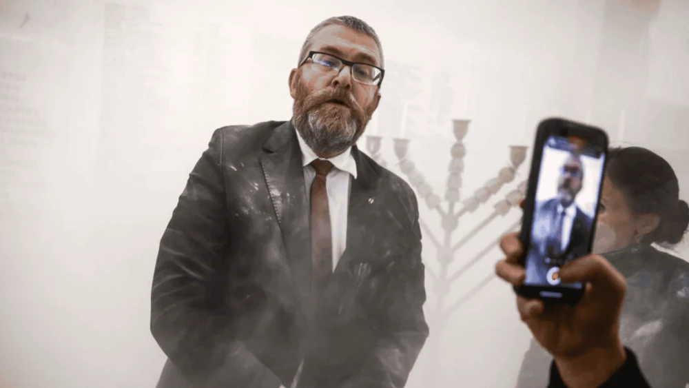Grzegorz Braun stands next to a Hanukkah menorah after using a fire extinguisher on it inside the Polish parliament in Warsaw, Poland on Dec. 12, 2025. Photo courtecy of Rabbi Sholem Stambler.
