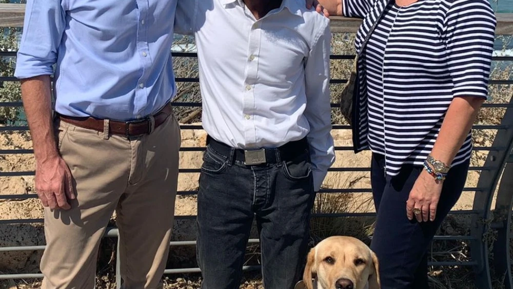 From left, British Ambassador to Israel Neil Wigan, blind marathon runner Avi Solomon with guide dog Nike, and Justine Zwerling, head of Primary Markets, Israel, at the London Stock Exchange. Photo by Yasmin Kaye/British Embassy.