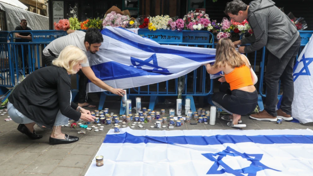 Israelis light candles at the scene of a terror attack on Dizengoff Street in central Tel Aviv, the day after a terrorist gun shooting that left multiple people dead, April 8, 2022. Photo by Noam Revkin Fenton/Flash90.