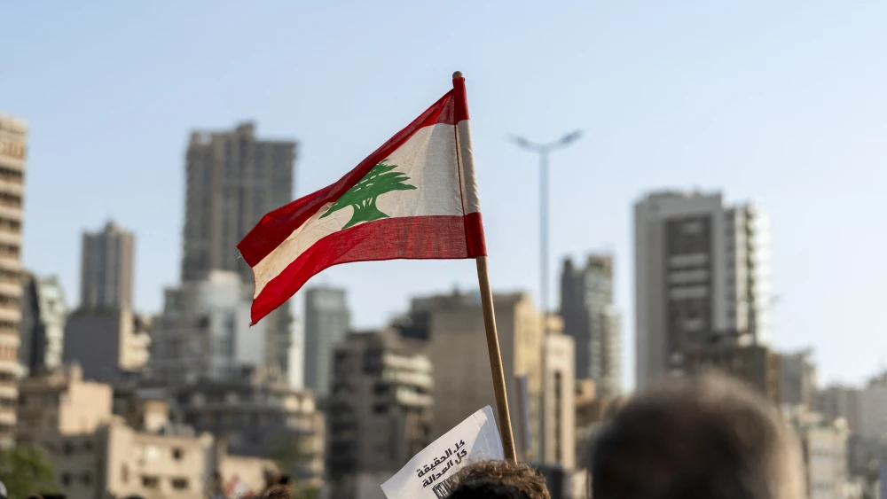 A participant in an event commemorating the sixth anniversary of the Beirut Port explosion waves a Lebanese flag, Beirut, Lebanon, Aug. 4, 2026. Photo by Silvia Casadei/Middle East Images/AFP via Getty Images.