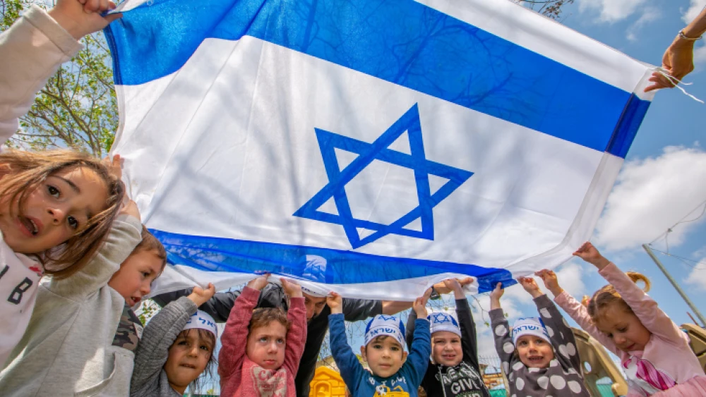 Israeli children hold Israeli flags ahead of the country's 73rd Independence Day, at a kindergarten in Moshav Yashresh, April 13, 2021. Photo by Yossi Aloni/Flash90.