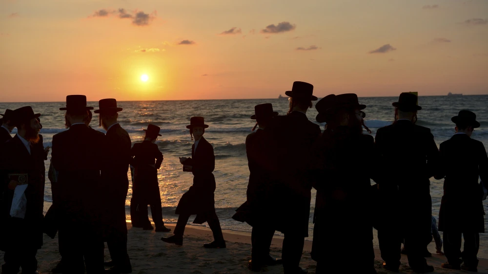Chassidic men pray on the beach on Sept. 17, 2018 in the southern Israeli city of Ashdod as part of the High Holiday ritual of Tashlich, where believers symbolically cast off their sins into the water. Typically done on Rosh Hashanah, the tradition can take place up until Hoshanah Rabbah, the seventh day of the Jewish holiday of Sukkot. Photo by Yossi Zeliger/Flash90.