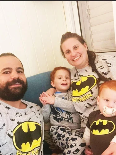 Yarden and Shiri Bibas with their sons, Ariel and Kfir, wearing Batman suits. Credit: Courtesy of the Bibas family.