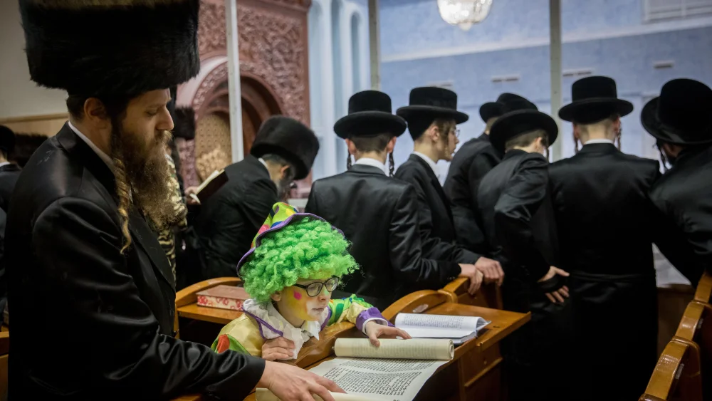 Ultra-Orthodox Jewish men and children read the Scroll of Esther, which tells the story of the Jewish festival of Purim, inside Yeshiva Belz (Chassidic dynasty) in Jerusalem, March 21, 2019. Photo by Yonatan Sindel/Flash90.