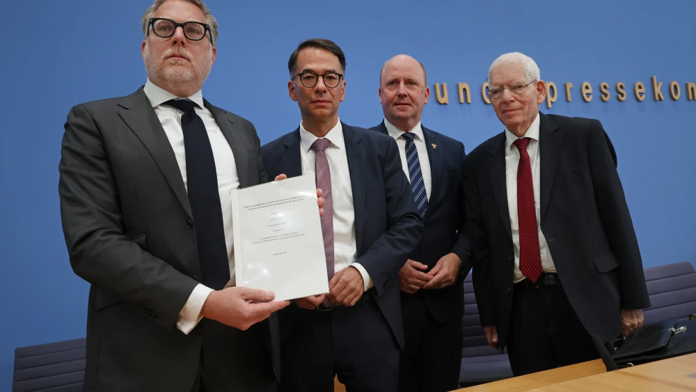 Steffen Augsberg, left, a law professor at Justus Liebig University in Giessen, Christian Heinz, Hessian Minister of Justice, Uwe Becker, Hessian State Commissioner for Jewish Life and Against Antisemitism, and Josef Schuster, President of Germany's Central Council of Jews, pose with a draft bill that would criminalize public denials of Israel's right to exist at a press conference on October 05, 2026 in Berlin, Germany. Photo by Sean Gallup/Getty Images.