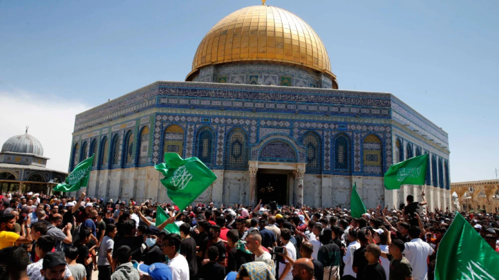 People hold Hamas flags as Palestinians gather after performing the last Friday of Ramadan to protest over the possible eviction of several Palestinian families from homes on land claimed by Jewish settlers in the East Jerusalem neighborhood of Sheikh Jarrah, May 7, 2021. Photo by Jamal Awad/Flash90