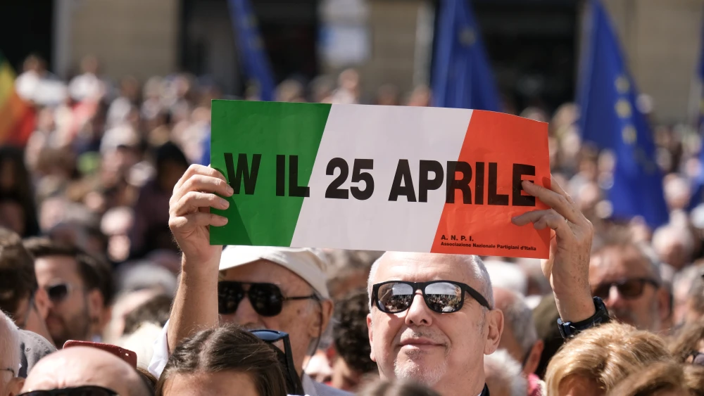 A man holding a sign reading "Long live April 25" is seen in Piazza Matteotti during Liberation Day celebrations in Genoa, Italy on April 25, 2026. Photo by Emanuela Zampa/Getty Images.
