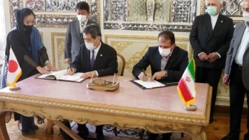 Japanese Ambassador to Iran Kazutoshi Aikawa and Mahdi Mirashrafi, president of Iran's Customs Administration and deputy finance minister, sign a customs agreement in Tehran on Aug. 22, 2021, in the presence of Japanese Foreign Minister Toshimitsu Motegi (top left) and his Iranian counterpart (standing, far right) Mohammed Javad Zarif. Credit: Foreign Ministry of Japan.
