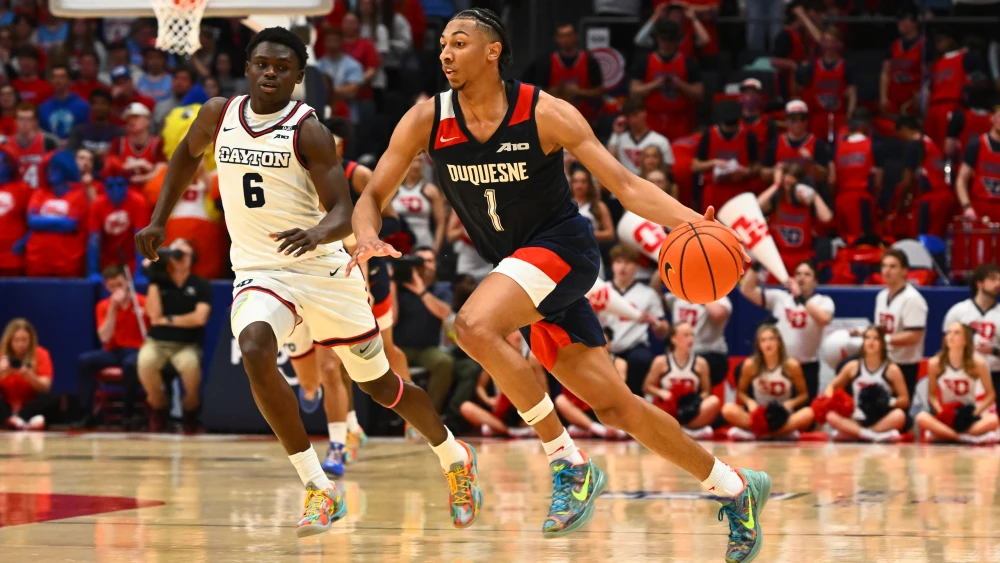 Cam Crawford #1 of the Duquesne Dukes advances the ball away from Enoch Cheeks #6 of the Dayton Flyers during the first half of a game at UD Arena, Feb. 15, 2025, Dayton, Ohio. Photo by Ben Jackson/Getty Images.