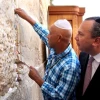 Hip-hop mogul Russell Simmons places a note in the Western Wall during his recent trip to Israel. Behind him is his partner for Muslim-Jewish dialogue work, New York Rabbi Marc Schneier. Photo by Sasson Tiram.