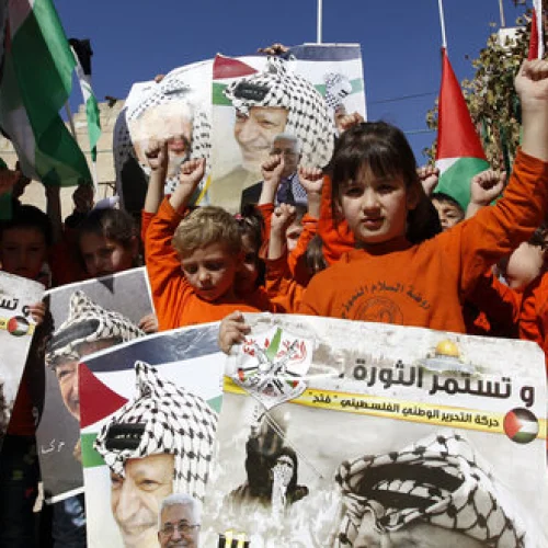 Palestinian children hold posters with the picture of former Palestinian head Yasser Arafat and current Palestinian Authority leader Mahmoud Abbas during a rally in Hebron marking the 12th anniversary of Arafat’s death Nov. 10, 2016. Credit: Wisam Hashlamoun/Flash90.