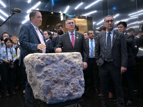 Israeli Foreign Minister Gideon Sa'ar (center) stands behind a stone on display that was part of a fortified tower built by the Hasmoneans in Jerusalem over 2,000 years ago, at the Israel Pavilion at Expo 2025 in Osaka, Japan, May 15, 2025. Photo by Shlomi Amsalem/MFA.